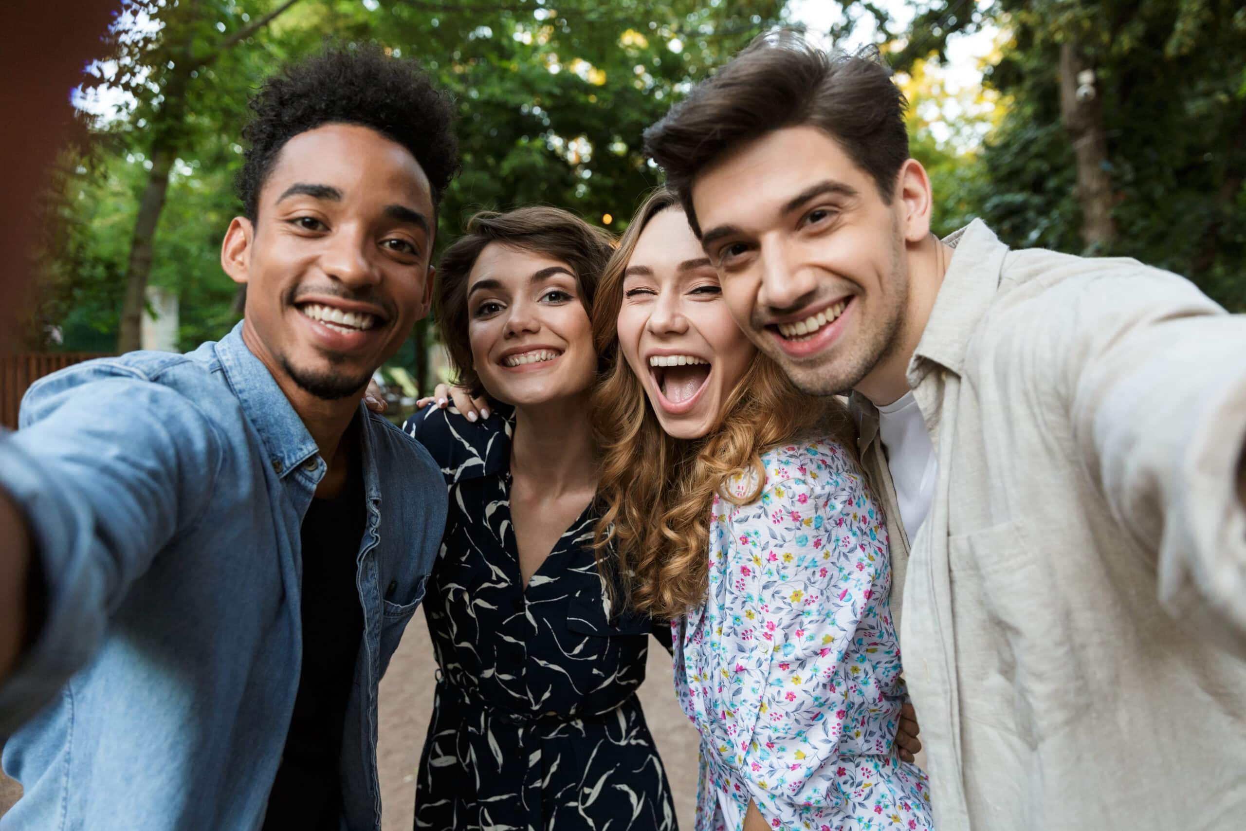 Image of happy young group of friends outdoors in park having fun take a selfie by camera.